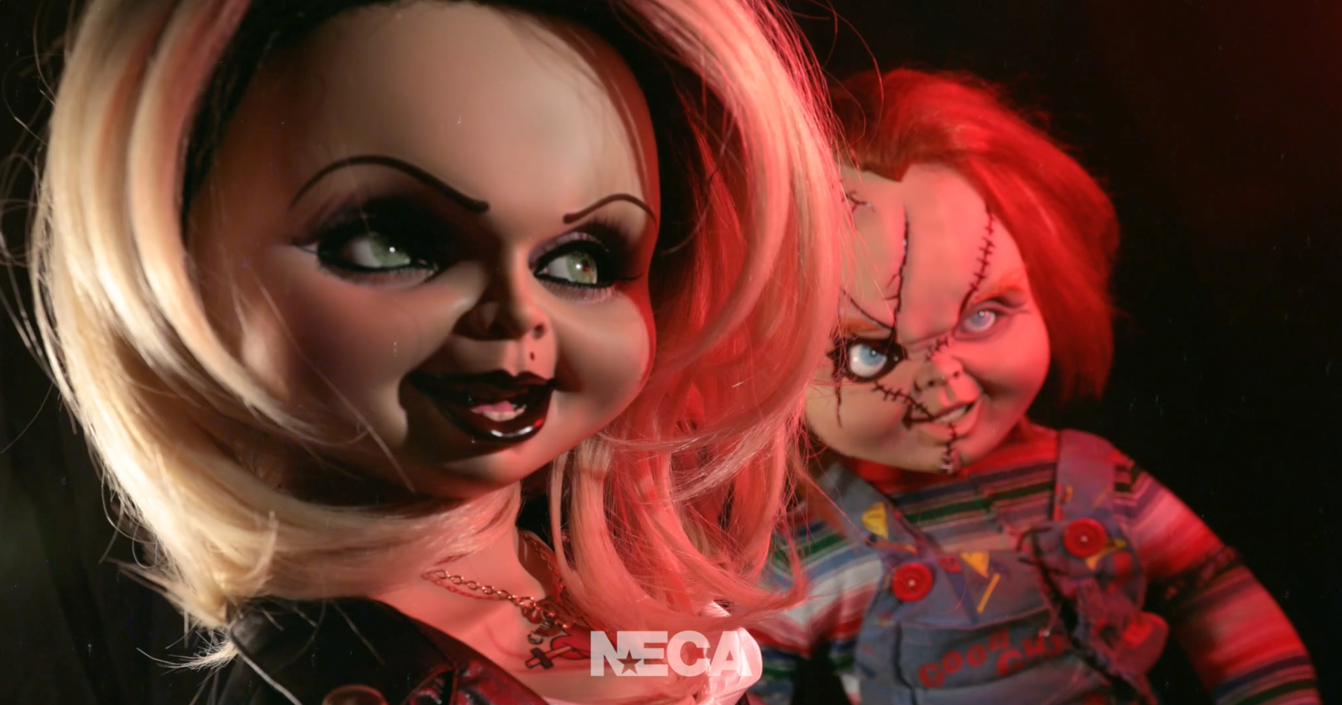 Load video: A life-sized Chucky doll breaks out of his packaging with a knife. He exchanges an evil smile with his bride, Tiffany. Across the room a man is peacefully painting so, of course, Chucky stabs him with the knife.